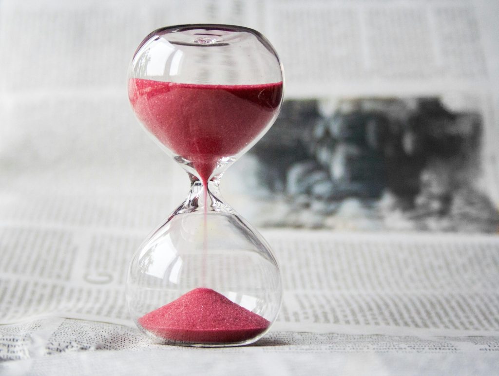 A scarcity advertising appeal depicted by an hourglass with red sand that is falling.